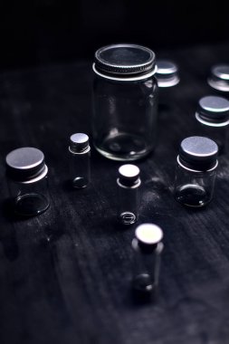 Siyah bir yüzeye boş küçük kavanozlar.