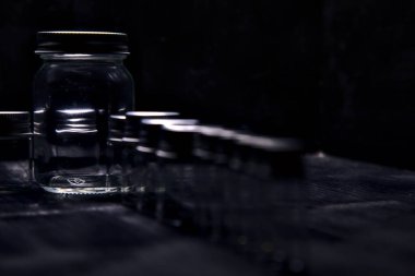 Siyah bir yüzeye boş küçük kavanozlar.