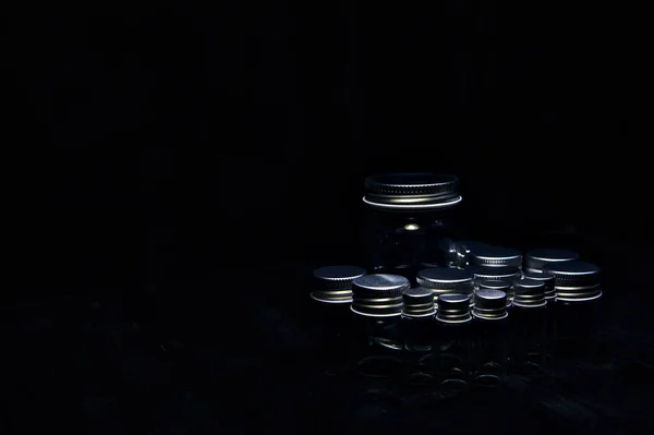 Empty tiny jars on a black surface