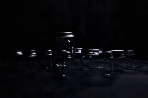 Empty tiny jars on a black surface