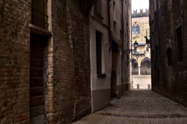 Uzakta bir kale cephesi olan bir İtalyan kasabasında sokak.