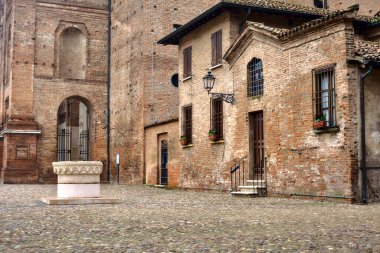 Yanı başında su kuyusu olan antik bir evin cephesi.