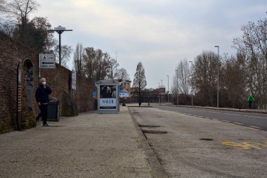 İtalya 'da kışın bulutlu bir günde otobüs durağı olan yol