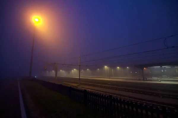 Spoorwegstation Bij Zonsondergang Een Mistige Dag Gezien Vanaf Verte — Stockfoto