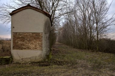 İtalya kırsalında, toprak bir yolun kenarındaki parkta bir kulübe.