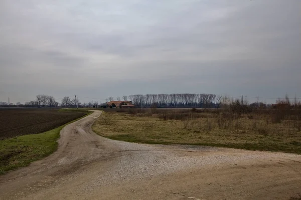 通往意大利乡间冬季耕地遍地的乡村房屋的碎石路 — 图库照片