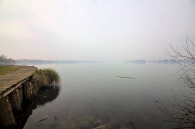 Kışın sisli bir günde Jetty gölün kıyısında