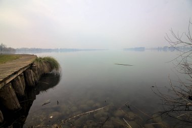 Kışın sisli bir günde Jetty gölün kıyısında