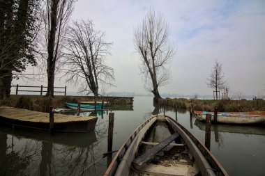 Kışın sisli bir günde bir nehrin körfezinde tekneli Jetty