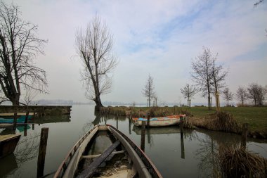 Kışın sisli bir günde bir nehrin körfezinde tekneli Jetty