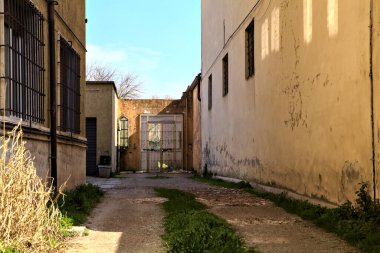 Kırık camlı kapıya çıkan bir bahçedeki çakıl yolu.