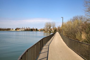 İlkbaharın başlarında bir İtalyan kasabasında bir gölün üzerinde panoramik yürüyüş.