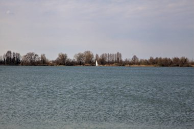 Baharın başında bir göldeki yelkenliler uzaklardan görülebiliyor.