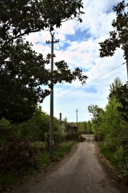 Bulutlu bir günde terk edilmiş bir kır evine giden yol