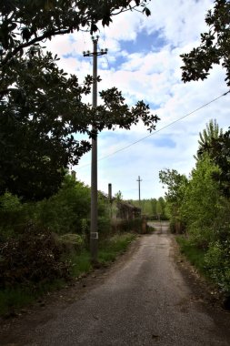 Bulutlu bir günde terk edilmiş bir kır evine giden yol