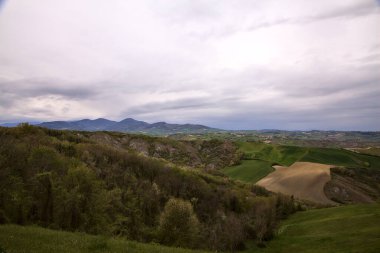 Fields and woods on the ridges of hills on a rainy day in the italian countryside