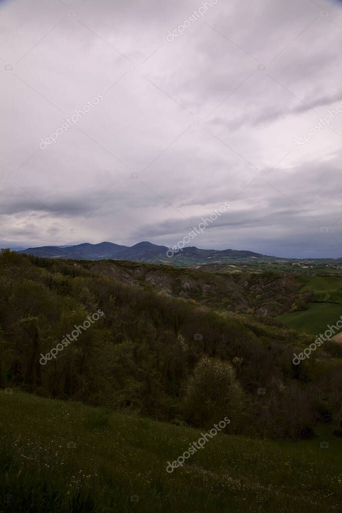 Fields and woods on the ridges of hills on a rainy day in the italian ...