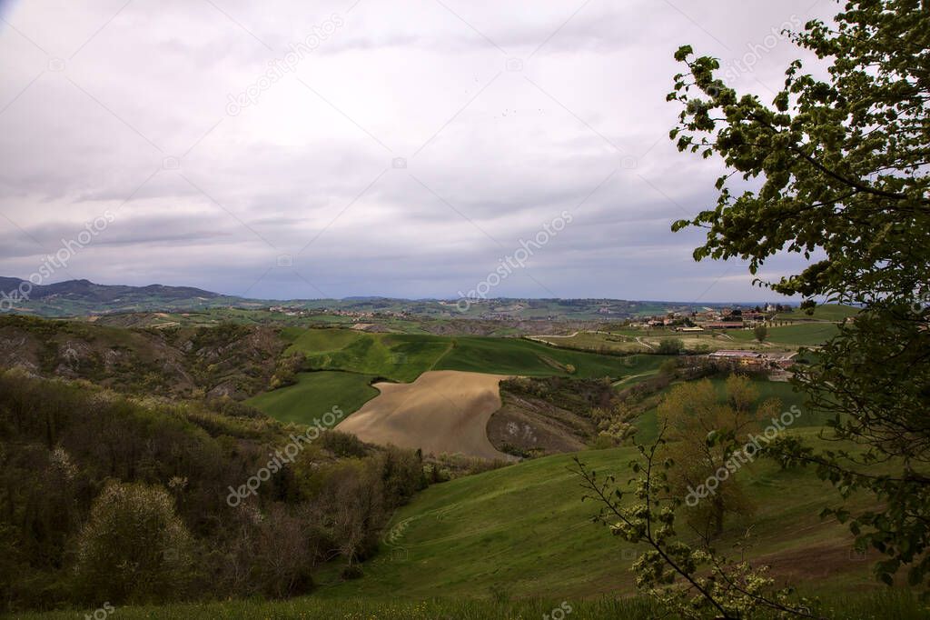 Fields and woods on the ridges of hills on a rainy day in the italian ...