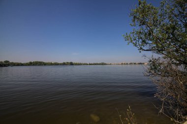 Açık bir baharda göl ve uzak bir kasaba.