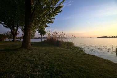 Gün batımında bir gölün kıyısında