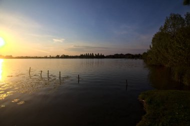 Gün batımında bir gölün kıyısında