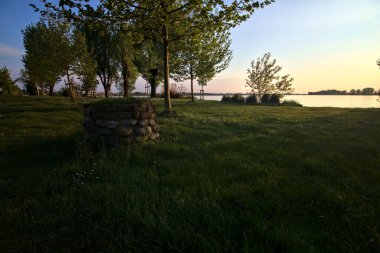 Gün batımında bir gölün kıyısında