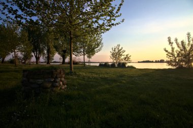 Gün batımında bir gölün kıyısında