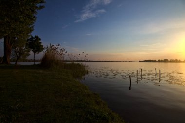 Gün batımında bir gölün kıyısında