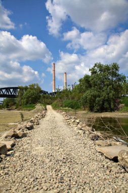 İtalya kırsalında, açık bir baharda kurumuş bir nehir yatağında kayalık bir yol.