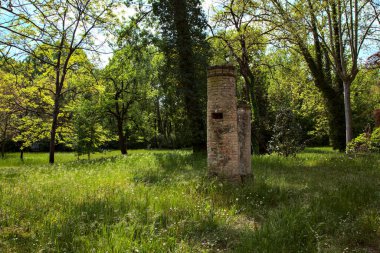 Remains of a manual water pump in the middle of a field in a park