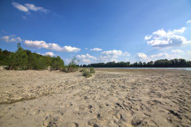 Dried river bed turned in a beach next to a park in the italian countryside