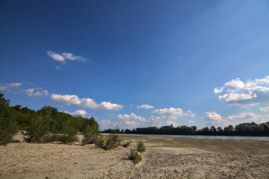 Dried river bed turned in a beach next to a park in the italian countryside