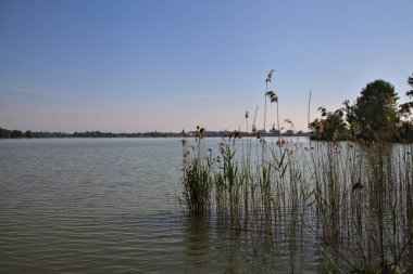 Üzerine uzanan bir nehrin kıyısı olan bir İtalyan kasabasına park et.