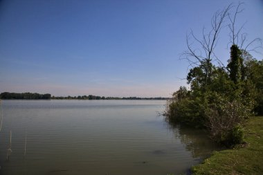 Üzerine uzanan bir nehrin kıyısı olan bir İtalyan kasabasına park et.