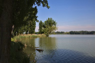 Üzerine uzanan bir nehrin kıyısı olan bir İtalyan kasabasına park et.