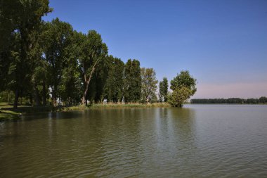 Üzerine uzanan bir nehrin kıyısı olan bir İtalyan kasabasına park et.