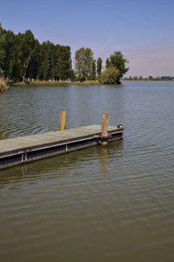Arka planda uzanan bir kıyısı olan bir nehre demirlemek