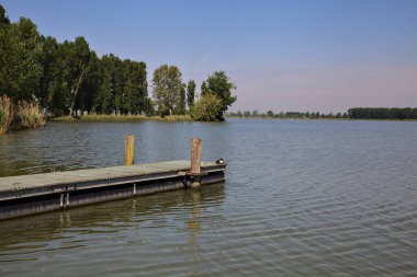 Arka planda uzanan bir kıyısı olan bir nehre demirlemek