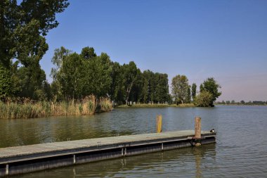 Arka planda uzanan bir kıyısı olan bir nehre demirlemek