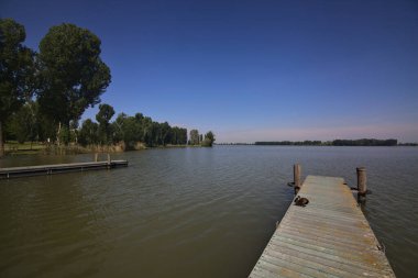 Arka planda uzanan bir kıyısı olan bir nehre demirlemek
