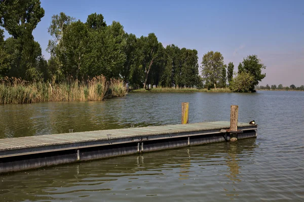 Arka planda uzanan bir kıyısı olan bir nehre demirlemek