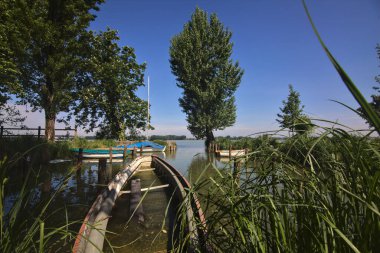 İtalya 'nın kırsal kesimindeki bir parkta rıhtımlı tekneleri olan bir nehrin körfezi.