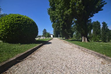 İlkbaharda bir İtalyan kasabasında halk parkında ağaçlarla çevrili bir yol.