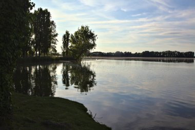Baharda gün batımında gölgede bir gölün kıyısında
