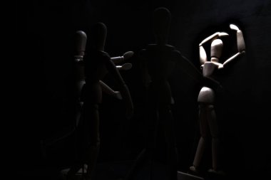 Duvara dayanmış umutsuzluğa kapılmış mankenler çiziyor.