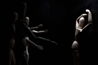 Duvara dayanmış umutsuzluğa kapılmış mankenler çiziyor.