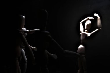 Duvara dayanmış umutsuzluğa kapılmış mankenler çiziyor.