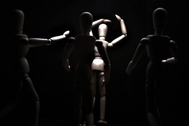 Duvara dayanmış umutsuzluğa kapılmış mankenler çiziyor.