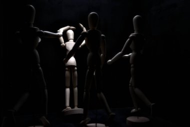 Duvara dayanmış umutsuzluğa kapılmış mankenler çiziyor.