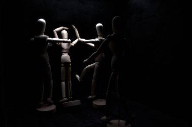 Duvara dayanmış umutsuzluğa kapılmış mankenler çiziyor.